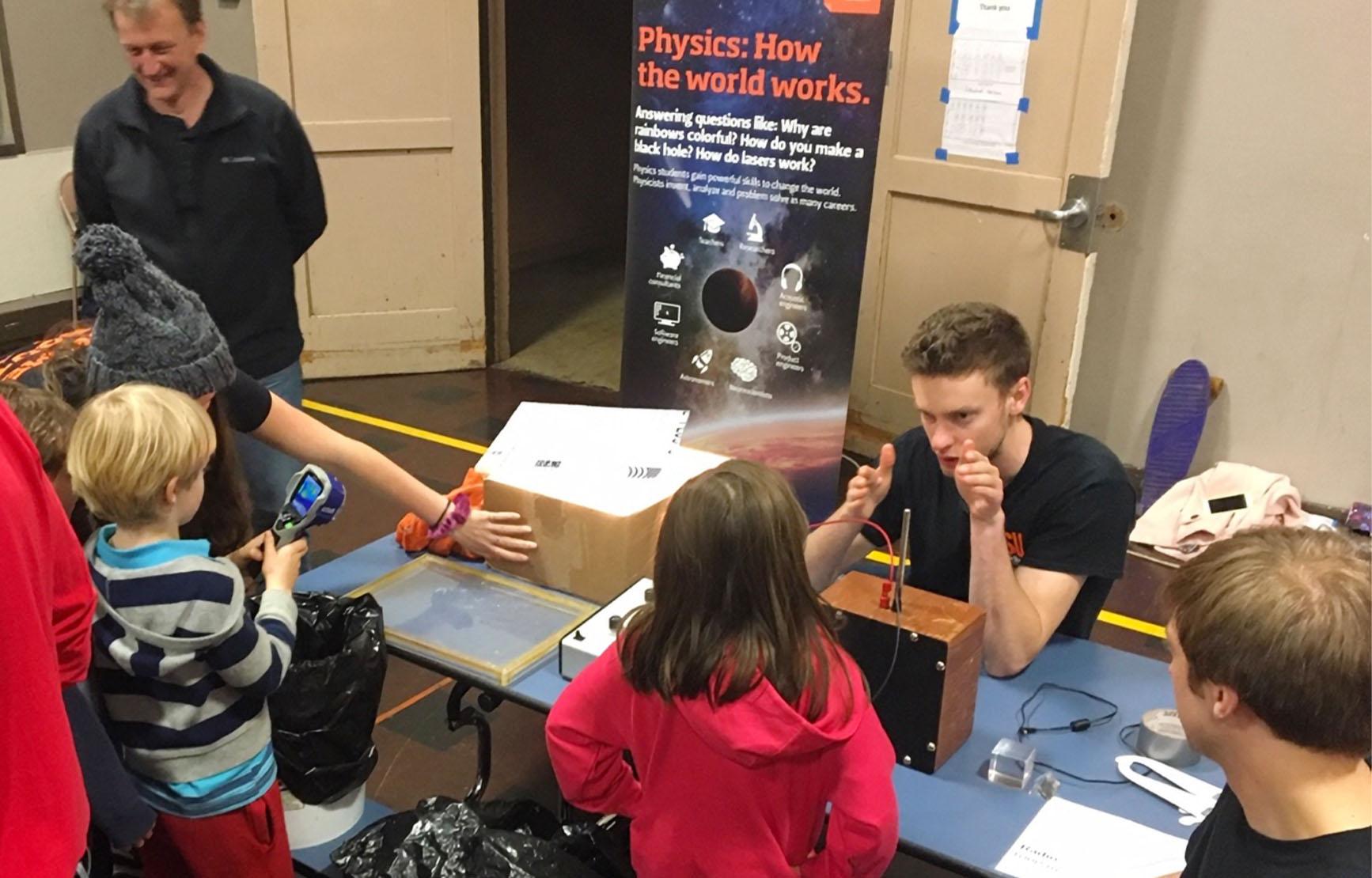 Physics students at a table during Discovery Days